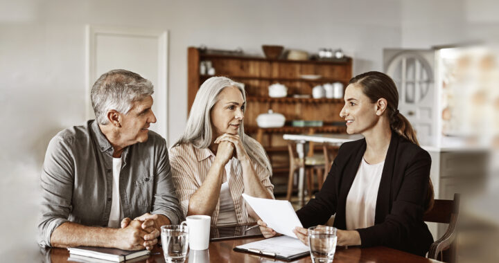 Mature couple with financial advisor at home.