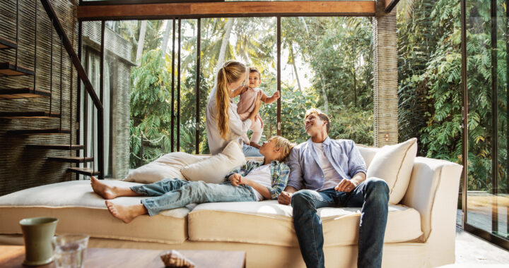 A young family seated on the sofa in the living room.